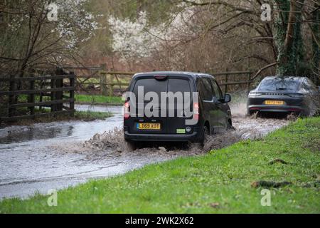 Eton, Windsor, Großbritannien. Februar 2024. Autofahrer, die in einem Land in Eton, Windsor, Berkshire, nach starkem nächtlichem Regen durch Hochwasser fahren. Quelle: Maureen McLean/Alamy Live News Stockfoto