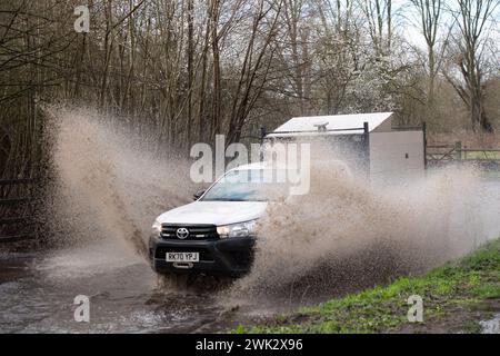 Eton, Windsor, Großbritannien. Februar 2024. Ein Autofahrer fährt nach starkem nächtlichem Regen mit hoher Geschwindigkeit durch Fluten, die Passanten in einem Land in Eton, Windsor, Berkshire vorbeispritzen. Quelle: Maureen McLean/Alamy Live News Stockfoto