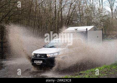 Eton, Windsor, Großbritannien. Februar 2024. Ein Autofahrer fährt nach starkem nächtlichem Regen mit hoher Geschwindigkeit durch Fluten, die Passanten in einem Land in Eton, Windsor, Berkshire vorbeispritzen. Quelle: Maureen McLean/Alamy Live News Stockfoto