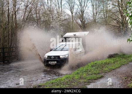 Eton, Windsor, Großbritannien. Februar 2024. Ein Autofahrer fährt nach starkem nächtlichem Regen mit hoher Geschwindigkeit durch Fluten, die Passanten in einem Land in Eton, Windsor, Berkshire vorbeispritzen. Quelle: Maureen McLean/Alamy Live News Stockfoto