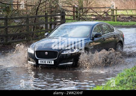 Eton, Windsor, Großbritannien. Februar 2024. Autofahrer, die in einem Land in Eton, Windsor, Berkshire, nach starkem nächtlichem Regen durch Hochwasser fahren. Quelle: Maureen McLean/Alamy Live News Stockfoto
