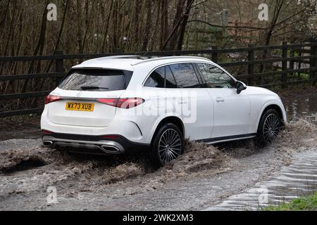 Eton, Windsor, Großbritannien. Februar 2024. Autofahrer, die in einem Land in Eton, Windsor, Berkshire, nach starkem nächtlichem Regen durch Hochwasser fahren. Quelle: Maureen McLean/Alamy Live News Stockfoto