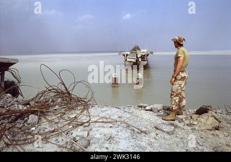 Erster Golfkrieg: 15. März 1991 Ein Koalitionssoldat steht an der Stelle, an der zwei Abschnitte der Brücke zur Bubiyan Island im Nordosten Kuwaits ins Wasser gefallen sind. Die Brücke wurde im Luftkrieg mit dem Irak von Flugzeugen der USAF bombardiert. Es wurde schließlich 1999 repariert. Stockfoto