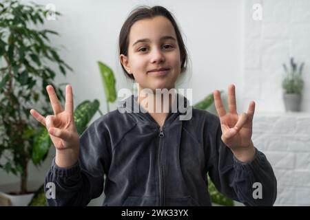 Wunderschönes, lächelndes, taubes Mädchen, das Gebärdensprache benutzt. Stockfoto