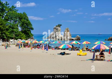 Donghae City, Südkorea - 28. Juli 2019: Der malerische Huam Beach, der mit bunten Sonnenschirmen auf seiner Sandfläche geschmückt ist, bietet eine atemberaubende Aussicht Stockfoto