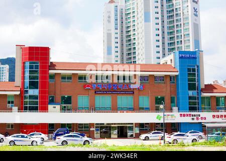Donghae City, Südkorea - 28. Juli 2019: Die Backsteinfassade des Intercity Bus Terminals von Donghae City steht mit einem Hochhaus-Apartment im Vordergrund Stockfoto