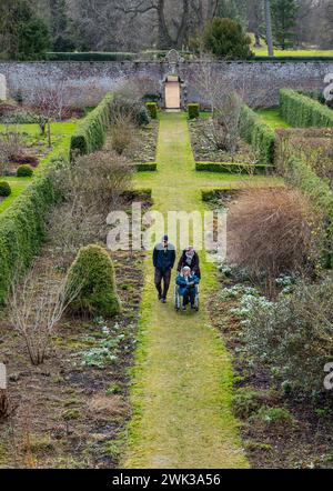 Preston Hall Walled Garden, Midlothian, Schottland, Großbritannien 18. Februar 2024. Scotland's Garden Scheme Snowdrop Weekend: Der ummauerte Garten aus dem 18. Jahrhundert ist für die Öffentlichkeit zugänglich. Die Eintrittsgelder gehen an wohltätige Zwecke. Es wurde in den letzten Dutzend Jahren restauriert. Die Leute laufen im formellen Garten. Quelle: Sally Anderson/Alamy Live News Stockfoto