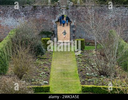 Preston Hall Walled Garden, Midlothian, Schottland, Großbritannien 18. Februar 2024. Scotland's Garden Scheme Snowdrop Weekend: Der ummauerte Garten aus dem 18. Jahrhundert ist für die Öffentlichkeit zugänglich. Die Eintrittsgelder gehen an wohltätige Zwecke. Es wurde in den letzten Dutzend Jahren restauriert. Die Leute laufen im formellen Garten. Quelle: Sally Anderson/Alamy Live News Stockfoto