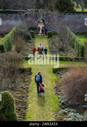 Preston Hall Walled Garden, Midlothian, Schottland, Großbritannien 18. Februar 2024. Scotland's Garden Scheme Snowdrop Weekend: Der ummauerte Garten aus dem 18. Jahrhundert ist für die Öffentlichkeit zugänglich. Die Eintrittsgelder gehen an wohltätige Zwecke. Es wurde in den letzten Dutzend Jahren restauriert. Die Leute laufen im formellen Garten. Quelle: Sally Anderson/Alamy Live News Stockfoto