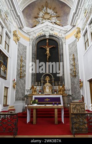 Niederösterreich, Österreich. Hauptaltar mit Kruzifix in der Pfarrkirche Laxenburg Stockfoto