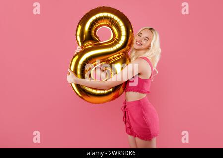 Glückliche Frau mit 8 Ballons in rosa Outfit Stockfoto