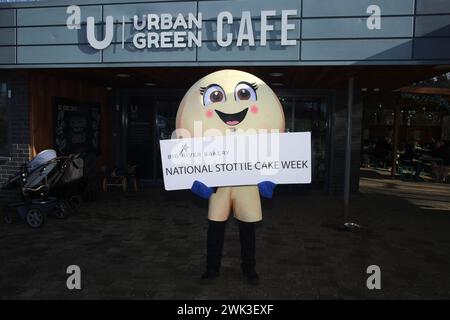 National Stottie Cake Week mit Scotty, dem Maskottchen der Big River Bakery, im Urban Green Exhibition Park Café. Die Big River Bakery, eingebettet im Herzen von Shieldfield, Newcastle, hat kürzlich eine kulinarische Premiere angekündigt: Die National Stottie Cake Week. Ein Backtie ist eine Art Brot, das rund, flach und auf dem Boden eines Ofens gebacken ist, was eine herrlich weiche, aber zähe Textur ergibt. Der Name leitet sich von dem Geordie-Wort „stot“ ab – was „hüpfen“ bedeutet –, da traditionell ein perfekt gekochtes Stottie beim Ablassen hüpfen sollte. Newcastle upon Tyne, 18. Februar 2024, Credit:DEWAlamy Stockfoto