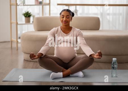 Friedliche afroamerikanerin, die zu Hause meditiert Stockfoto