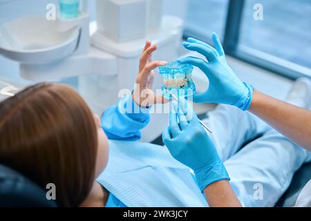 Die Ärztin hält ein Gebiss in den Händen Stockfoto