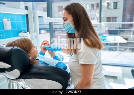 Frau in einer Zahnklinik unterrichtet ein Kind Mundhygiene Stockfoto