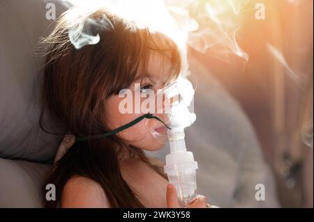 Kaukasisches Mädchen Kind mit Inhalator Maske zu Hause in Dampf sonnigen Hintergrund Stockfoto