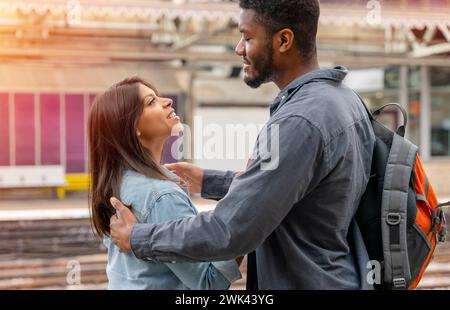 Ein junges, schönes Paar umarmt sich auf der Plattform und verabschiedet sich vom Ehepartner, Freund. Reise-Lifestyle-Konzept Stockfoto