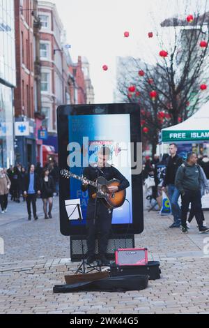 Ein Straßenmusiker spielt Gitarre und singt in der Market Street Manchester Stockfoto