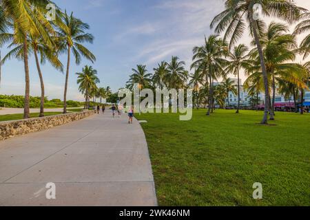 Wunderschöner Blick auf den Ocean Drive in Miami Beach Park mit Leuten, die bei Sonnenuntergang auf Parkwegen spazieren gehen. Miami Beach. USA. Stockfoto