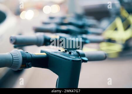 Eine Reihe von Elektrorollern, die am Straßenrand geparkt sind Stockfoto