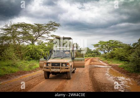 Ein Fahrer und Reiseleiter hebt das Dach seines Geländewagens auf einer Safari im Nyerere Nationalpark (Selous Game Reserve) in Tansania. Stockfoto