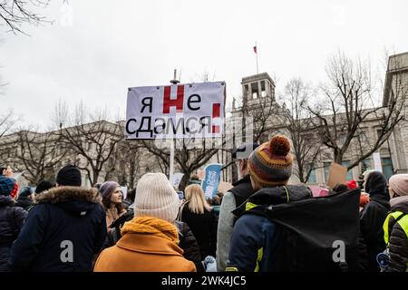 Berlin, Deutschland. Februar 2024. Eine Frau hält während einer Massendemonstration rund um die russische Botschaft in Berlin nach dem Tod des russischen Oppositionsführers Alexej Nawalny ein Plakat von Putin mit einem X durch. Quelle: SOPA Images Limited/Alamy Live News Stockfoto