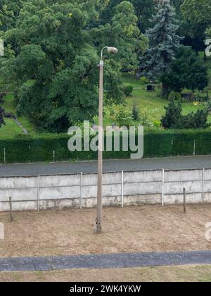 Blick nach unten auf einen originalen Lichtpfosten im Niemandsland auf den erhaltenen Abschnitt der Bernauer Straße der Berliner Mauer, Berlin, Deutschland. Stockfoto