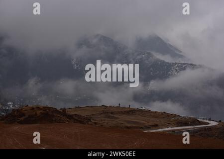 Srinagar, Kaschmir, Indien. Februar 2024. Die Bewohner spazieren an einem regnerischen Tag entlang des Hügels am Stadtrand von Srinagar, der Sommerhauptstadt von Jammu und Kaschmir. Neuschneefälle wurden in den höheren Bergen Kaschmirs gemeldet, während die Ebenen Regenfälle erlebten, die zu einem deutlichen Temperaturabfall führten. Das Wetteramt hat für die nächsten drei Tage mittelschwere bis starke Schneefälle oder Regenfälle im Kaschmirtal prognostiziert. (Credit Image: © Saqib Majeed/SOPA Images via ZUMA Press Wire) NUR REDAKTIONELLE VERWENDUNG! Nicht für kommerzielle ZWECKE! Stockfoto