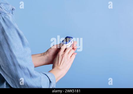 Frauen-Selbsttest auf Blutsauerstoffspiegel mit dem Pulsoxymeter Stockfoto