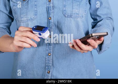 Frauen-Selbsttest auf Blutsauerstoffspiegel mit dem Pulsoxymeter Stockfoto