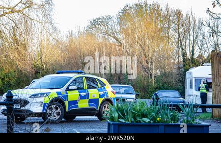 Wiltshire Polizeiauto parkt mit einer Polizistin im Hintergrund. Ländliche Polizeiarbeit im County Wiltshire UK Stockfoto