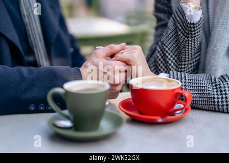 Gutaussehender Mann und schöne Frau, die sich umarmen, während sie durch die Stadt laufen, Kaffee trinken, Tee trinken, im Side Cafe sitzen, Spaß haben, Lifest Stockfoto