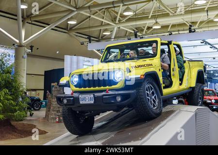 Ein gelbes Jeep Wrangler-Fahrzeug, das auf einem geschlossenen Kurs mit Hindernissen fährt Stockfoto