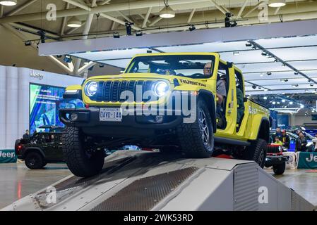 Ein gelbes Jeep Wrangler-Fahrzeug, das auf einem geschlossenen Kurs mit Hindernissen fährt Stockfoto