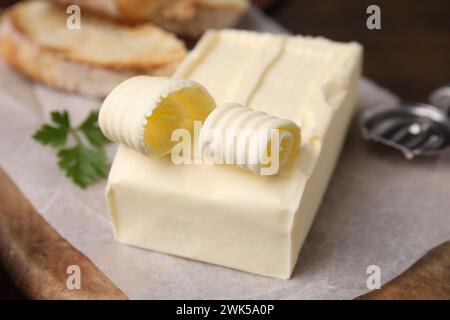 Leckere Butter und Löffel auf Holzbrett, Nahaufnahme Stockfoto