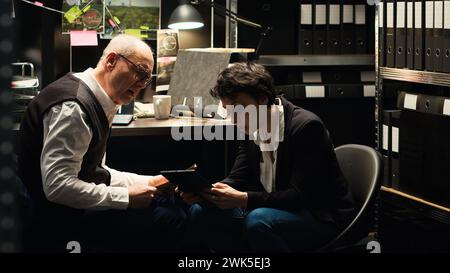 Anwaltsagenten analysieren forensische Beweise im Vorfallsraum, bewerten belastende Beweise, um Verdächtige zu erkennen. Kriminalexperten lesen Zeugenaussagen und vertrauliche Berichte, Detektivarbeit. Stockfoto