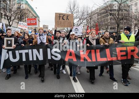 Berlin, Deutschland. Februar 2024. Demonstranten marschieren mit einem Banner und Plakaten, die ihre Meinung während einer Massendemonstration um die russische Botschaft in Berlin nach dem Tod des russischen Oppositionsführers Alexej Nawalny zum Ausdruck bringen. (Foto: Nicholas Müller/SOPA Images/SIPA USA) Credit: SIPA USA/Alamy Live News Stockfoto