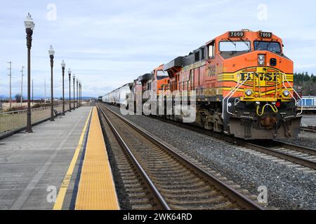 Stanwood, WA, USA - 2. Februar 2024; BNSF-Zug mit gemischter Güterladung am Bahnhof Stanwood mit Bahnsteigerkante Stockfoto