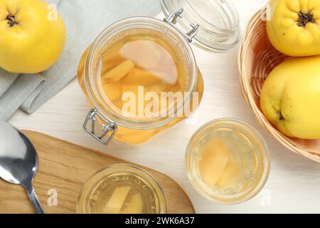 Köstliches Quittengetränk, frisches Obst und Löffel auf weißem Holztisch, flach gelegen Stockfoto