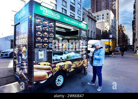 Frau, die vor einem Nathans Hot Dog Food Truck in New York City steht Stockfoto