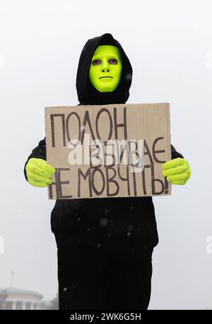 Ein Mann in einer Maske hält ein Plakat mit der Aufschrift "nicht schweigen - Gefangenschaft tötet" während einer Kundgebung auf Maidan Nezalezhnosti. Am Sonntag fand auf dem Maidan Nezalezhnosti in Kiew die traditionelle Freie Asow-Kundgebung von Verwandten und Freunden gefangener Soldaten statt. Verwandte und Freunde von gefangenen ukrainischen Soldaten kamen zu der Kundgebung, um uns daran zu erinnern, dass das ukrainische Militär und die Verteidiger von Mariupol noch immer in Gefangenschaft sind. Insgesamt versammelten sich etwa zweitausend Menschen auf dem Hauptplatz der Hauptstadt. Frauen und Mütter der Soldaten und ihre Kinder nahmen an der Kundgebung Teil. Soldaten und ehemalige Kriegsgefangene Stockfoto