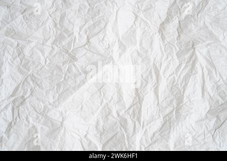 Zerknittertes oder zerknittertes weißes Schablonenpapier oder -Taschentuch nach Verwendung mit großem Kopierraum wird für die Hintergrundtextur verwendet. Stockfoto