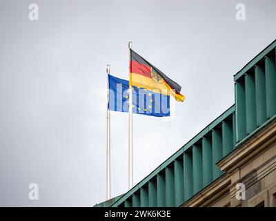 Flaggen Deutschlands und der Europäischen Union (EU) nebeneinander. Symbole für Demokratie, Zusammenarbeit und Freiheit in Europa auf einem Regierungsgebäude. Stockfoto