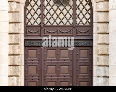 Deutsches Bundestagsschild in einer alten Holztür eines Regierungsgebäudes. Große Buchstaben an der Eingangstür einer Verwaltungseinheit. Stockfoto