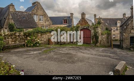 Blick auf traditionelle Steinhäuser unter bewölktem Himmel in einem alten Dorf Locronan Bretagne Stockfoto