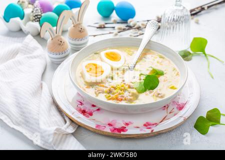 Hausgemachte polnische Ostersuppe mit Würstchen, hart gekochtem Ei und Gemüse in einer Schüssel Stockfoto