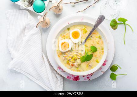 Hausgemachte polnische Ostersuppe mit Würstchen, hart gekochtem Ei und Gemüse in einer Schüssel Stockfoto