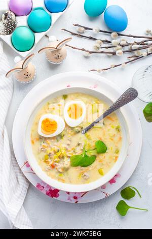 Hausgemachte polnische Ostersuppe mit Würstchen, hart gekochtem Ei und Gemüse in einer Schüssel Stockfoto