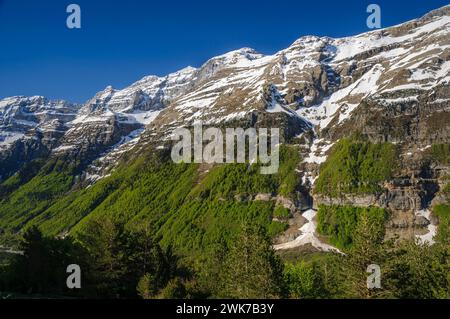 Pineta Valley an einem Frühlingsmorgen. Im Vordergrund eine Schlucht mit Überresten einer Winterlawine. Nationalpark Ordesa y Monte Perdido, Huesca, Spanien Stockfoto