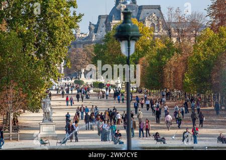 Malerische Übersicht mit Menschen, die in den Tuilerien spazieren gehen, im Hintergrund des Louvre-Museums in Paris, Frankreich. Stockfoto